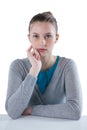 Confident teenage girl sitting against white background Royalty Free Stock Photo