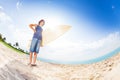 Confident teenager on beach with surfboard
