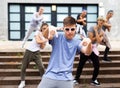 Confident teenager street dancer performing with group