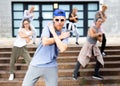 Confident teenager street dancer performing with group