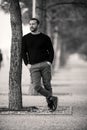 Confident Tough Handsome Man Posing, leaning against a tree Royalty Free Stock Photo