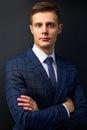 Confident trendy guy in formal suit posing on black background