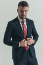 Confident unshaved man with beard buttoning elegant suit