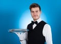 Confident waiter carrying tray