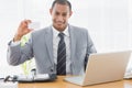 Confident well dressed man with business card at office desk Royalty Free Stock Photo