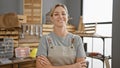 Confident woman carpenter standing in workshop with arms crossed Royalty Free Stock Photo