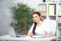 Confident woman doctor sitting at the table in her office and smiling at camera. healthcare concept Royalty Free Stock Photo