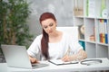 Confident woman doctor sitting at the table in her office and works at the computer. healthcare concept Royalty Free Stock Photo