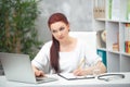 Confident woman doctor sitting at the table in her office and works at the computer. healthcare concept Royalty Free Stock Photo