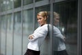 Confident woman leaning on office building window Royalty Free Stock Photo