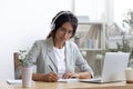 Confident woman student studying online in earphones by pc screen Royalty Free Stock Photo