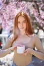 Confident woman using mousturizer cream jar for face in spring, outdoors, in garden Royalty Free Stock Photo