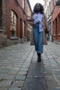 Confident Woman Walking Alone in Cobblestone Alley