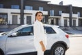 Confident woman in white formal wear outdoots near her white car Royalty Free Stock Photo