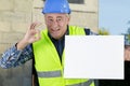 confident worker presenting empty board and making ok sing Royalty Free Stock Photo