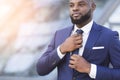 Young Black Businessman Adjusting Necktie In Urban Area Royalty Free Stock Photo