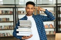 Confident young african male student holding stack of books Royalty Free Stock Photo