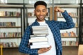 Confident young african male student holding stack of books Royalty Free Stock Photo