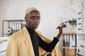 Confident young african man in formal wear writing on board with paper stickers Royalty Free Stock Photo