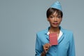 Confident young african stewardess holding passport in her hand. Royalty Free Stock Photo