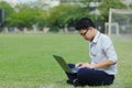 Confident young Asian business man in formal wear using laptop for his job at the field Royalty Free Stock Photo