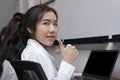 Confident young Asian business woman showing thump up in workplace of office Royalty Free Stock Photo