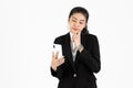 Confident young Asian business woman in suit with mobile smart phone having good idea posing over white isolated background. Think Royalty Free Stock Photo