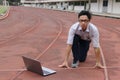 Confident young Asian businessman with laptop ready start position to forward on race track. business vision concept. Royalty Free Stock Photo