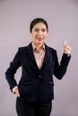 Confident young asian businesswoman in formal suit pointing finger. Enthusiastic Royalty Free Stock Photo