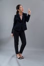 Confident young asian businesswoman in formal suit pointing finger. Enthusiastic Royalty Free Stock Photo
