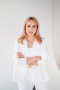 Confident young beautiful manager on white background. blonde girl in a white suit sits on a chair, on a white background. Strong