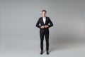 Confident young business man in classic black suit shirt posing isolated on grey background studio portrait. Achievement Royalty Free Stock Photo