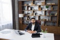 Confident young business man working on laptop at home office. Royalty Free Stock Photo