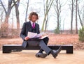 Confident young businessman reading document while sitting against window at office Royalty Free Stock Photo