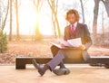 Confident young businessman reading document while sitting against window at office Royalty Free Stock Photo