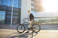 Confident young businessman walking with bicycle on the street in town. Royalty Free Stock Photo