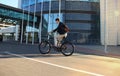 Confident young businessman walking with bicycle on the street in town. Royalty Free Stock Photo