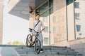 Confident young businessman walking with eco transport on street in town, going to work and active lifestyle Royalty Free Stock Photo