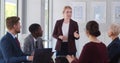 Confident young businesswoman giving presentation to team in office. Royalty Free Stock Photo