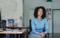 Confident young businesswoman sitting at her desk in an office Royalty Free Stock Photo