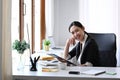 Confident businesswoman sitting at her office desk and smiling to camera. Royalty Free Stock Photo