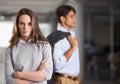 Determined business leader. A confident young businesswoman standing with arms folded and her colleague in the Royalty Free Stock Photo
