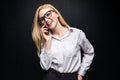 Confident young businesswoman talking on mobile phone wearing a suit standing isolated over black background Royalty Free Stock Photo