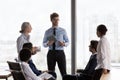 Confident young CEO man talking to team, speaking, instructing employees Royalty Free Stock Photo