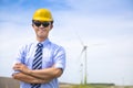 Confident young engineer standing with wind generator