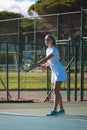 Confident young female caucasian player serving tennis ball with racket at court on sunny day Royalty Free Stock Photo