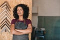 Confident young woman standing in her picture framing workshop