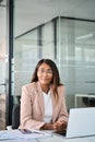 Confident young female lawyer in office sitting at desk, vertical portrait. Royalty Free Stock Photo