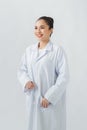 Confident young female pharmacist with a lovely friendly smile standing on color background