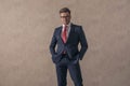 Confident young guy in elegant suit with glasses holding hands in pockets Royalty Free Stock Photo